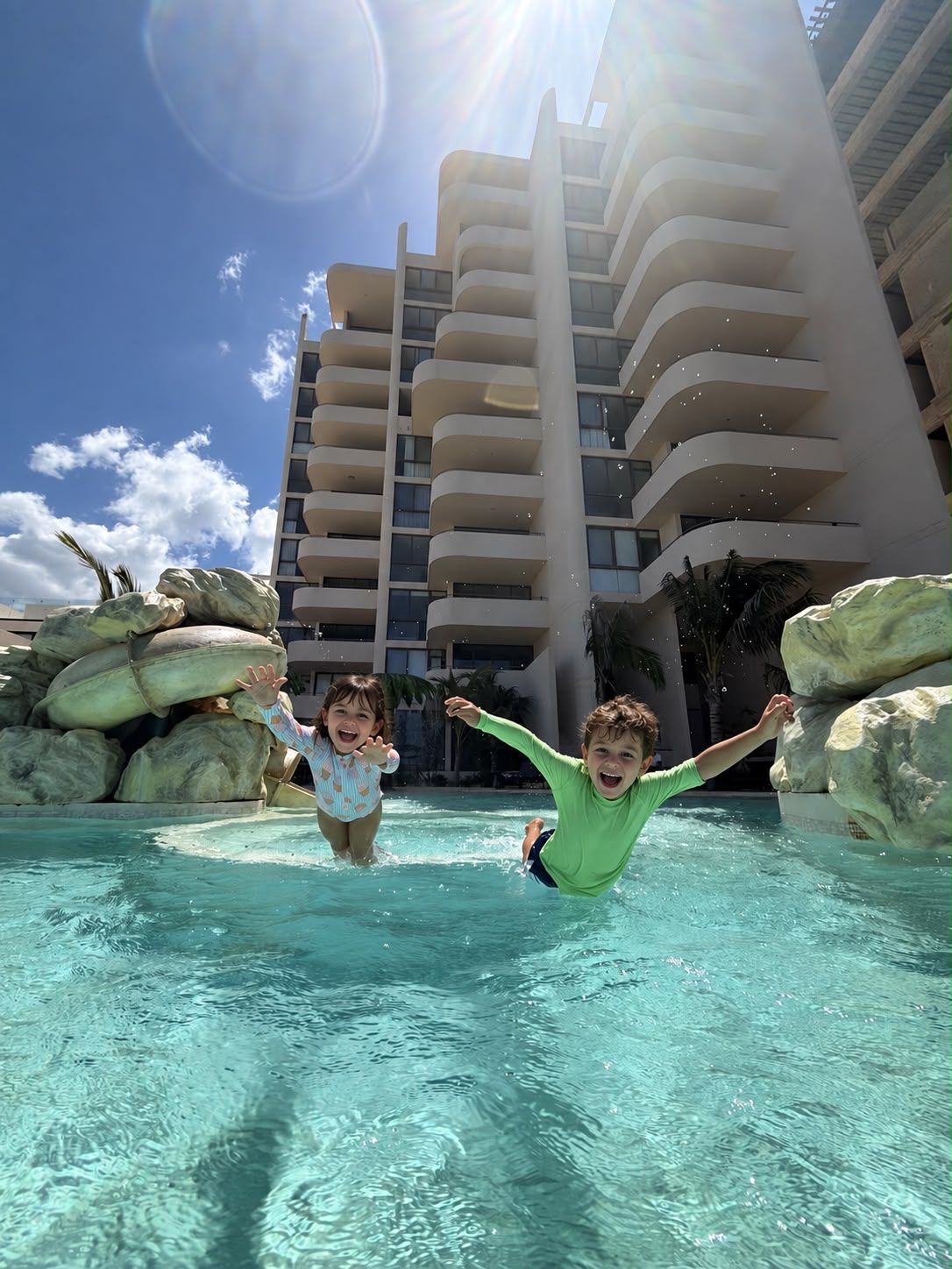 Kids jumping into the Petén d'Arenas pool, with the building behind them